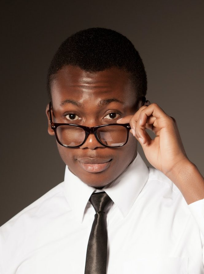 young positive handsome african businessman in stylish shirt tie and glasses standing with e1618173760762